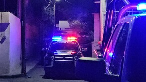 Se observa que es de noche, una patrulla de la policía municipal en medio de la calle.