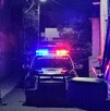 Se observa que es de noche, una patrulla de la policía municipal en medio de la calle.