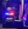 Se observa que es de noche, una patrulla de la policía municipal en medio de la calle.