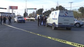 Se observan varios vehículos parados, hay un semáforo y una cinta amarilla de precaución.