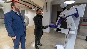 Samuel García saludando a robot.