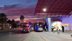 Se observan unos carros estacionados, una ambulancia y es de noche.