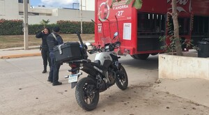Dos oficiales junto a una motocicleta de la Policía de Puerto Vallarta al lado de un camión de Coca-Cola