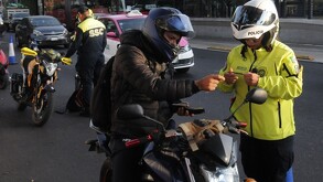 Un motociclista mostrando su licencia de conducir a un policía de transito durante un operativo en la CdMx