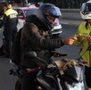 Un motociclista mostrando su licencia de conducir a un policía de transito durante un operativo en la CdMx