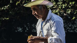 Adulto mayor comiendo al aire libre en la Ciudad de México.