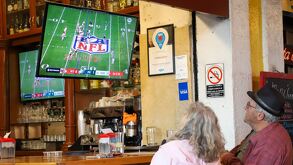 Una pareja de ancianos mira el Super Bowl desde un restaurante de Puebla.