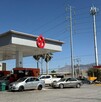 Se observa una gasolinera con autos estacionados, hay un número 7.