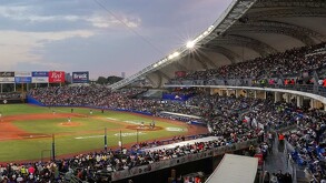 Una vista panorámica del Estadio Panamericano lleno de aficionados durante un juego nocturno de los Charros de Jalisco bajo un cielo crepuscular.