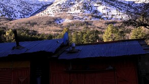 Se observan unas casas y una sierra atrás con nieve.