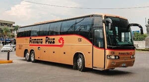 Autobús de la empresa Primera Plus circulando por calles de Guadalajara cerca de la Glorieta de la Minerva en un día nublado con autos alrededor