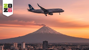 un avión volando sobre la ciudad de puebla con el volcán popocatépetl de fondo
