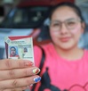una mujer muestra su licencia de conducir de puebla
