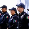 Tres hombres y dos mujeres miembros de la Policía de Jalisco formados delante de una barda blanca durante un operativo de seguridad