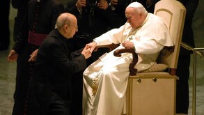 Sacerdote con el Papa besándole la mano.