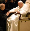Sacerdote con el Papa besándole la mano.