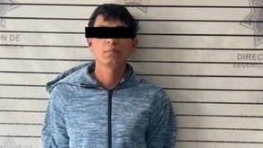 Se observa a un hombre con ojos tapados y vistiendo pantalón de mezclilla y sudadera.