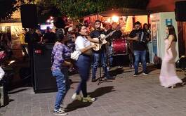 Personas bailando y un grupo tocando