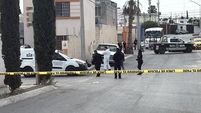 Se observa una persona en el suelo, con una cintilla amarilla de precaución y hay otros hombres con uniforme blanco.