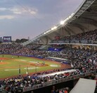 Una vista panorámica del Estadio Panamericano lleno de aficionados durante un juego nocturno de los Charros de Jalisco bajo un cielo crepuscular.