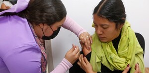 Mujer aplicando vacuna de sarampión a una joven en Jalisco