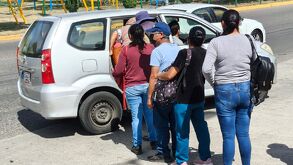 Personas se amontonan para alcanzar una unidad de taxi pirata que los lleve a sus destinos.