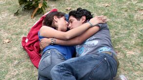 Mujer y hombre abrazados se acuestan juntos sobre un parque.