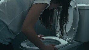 Joven agachada en un inodoro en color gris