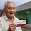 Adulto mayor recogiendo su tarjeta del Bienestar para Adultos Mayores.