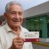 Adulto mayor recogiendo su tarjeta del Bienestar para Adultos Mayores.