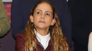 Mujer de cabello rubio y con semblante serio en una conferencia de prensa en Puebla.