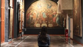 una mujer sentada en una banca observando una pintura en un museo de puebla