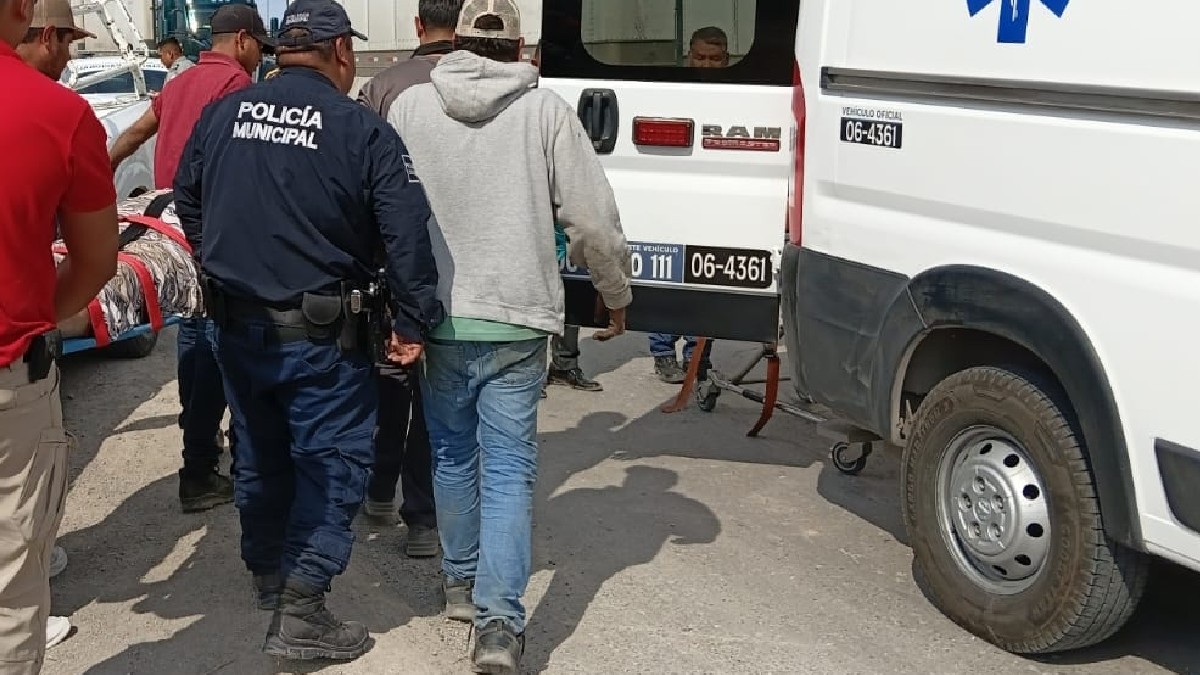 AMBULANCIA EN COLOR BLANCO Y VARIAS PERSONAS RODEANDOLA