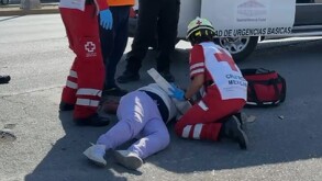 Se observa a una mujer titrada en el suelo que viste pantalón de mezclilla.