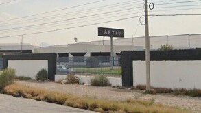 Se ve una construcción color gris y con un portón grande.