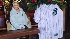 Se observa una fotografía de una adulta mayor con canas y a lado una playera del equipo Saraperos de Saltillo.