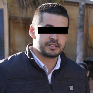 Diego Rivera Navarro, presidente municipal de Tequila, con los ojos censurados por un recuadro negro vistiendo un chaleco negro y con personas de fondo