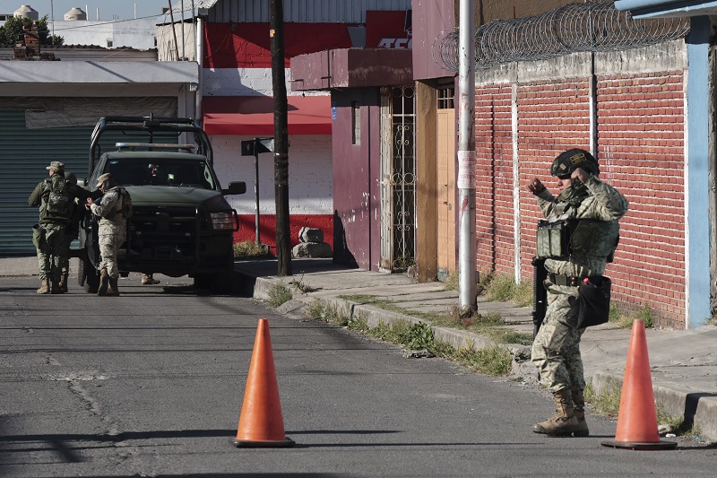 Militar realiza una maniobra junto a un cono de advertencia, en Puebla.