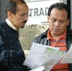 Se observa a dos hombres con unas hojas en las manos, las están observando.
