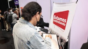 una persona llena una solicitud de empleo en una feria del empleo en puebla