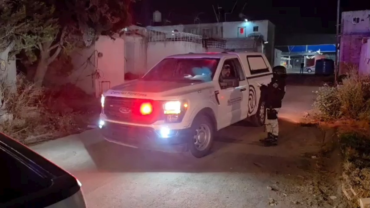 Camioneta del Instituto Jalisciense de Ciencias Forenses con un militar de la Guardia Nacional al lado en calles de El Salto