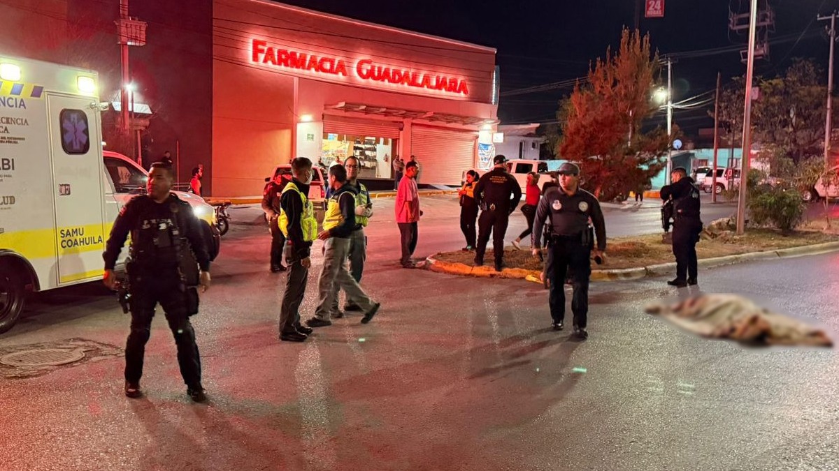 Se observa un cuerpo tendido en el suelo con una cobija arriba, hay policías y patrullas y una cinta amarilla de precaución.