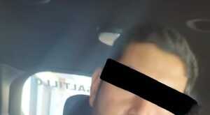 Se observa a un hombre con ojos tapados y usa una sudadera negra.