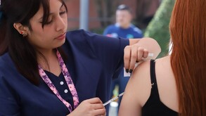 Enfermera vacunando a mujer contra el sarampión