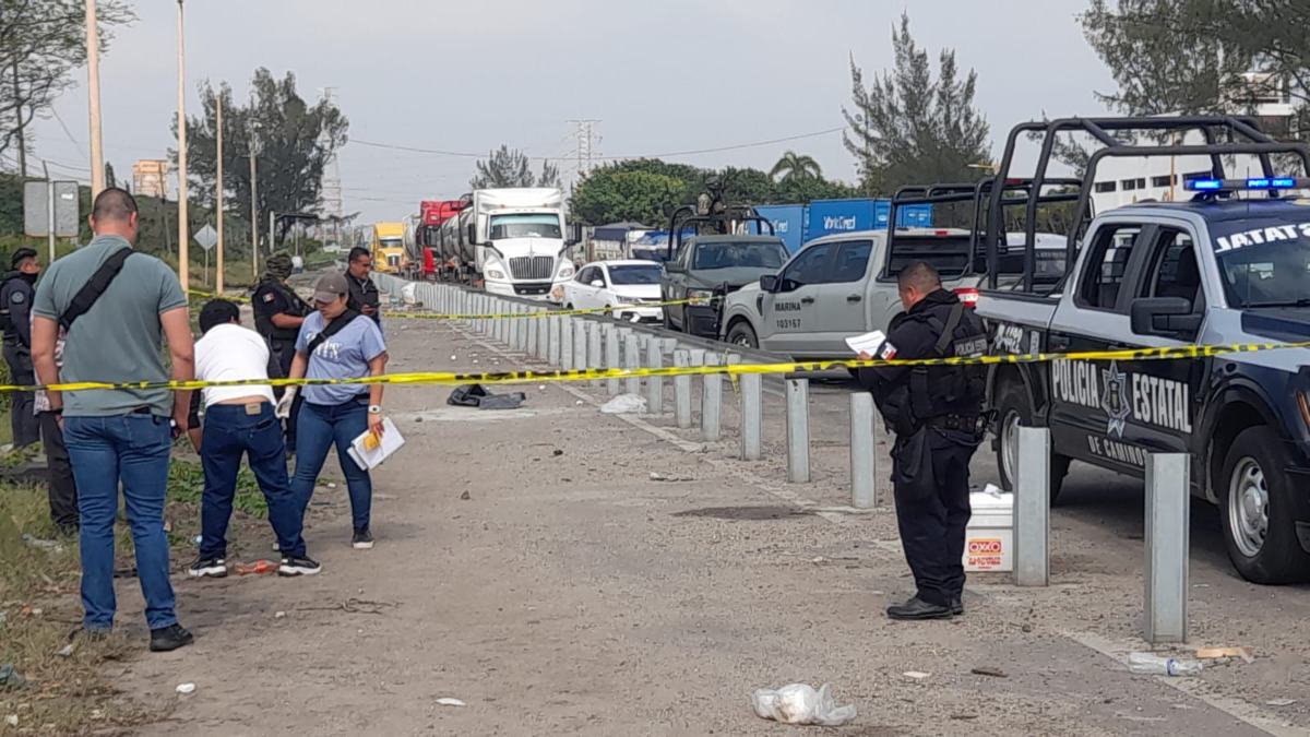 policías a un costado de una carretera en coatzacoalcos donde fue abandonada una hielera con restos humanos