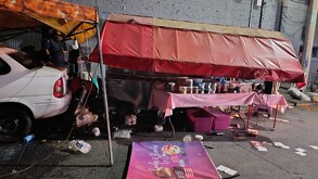 Puesto de comida dedicada a la venta de biónicos, lonches y burritas en calles de Guadalajara con un auto blanco estacionado a un lado