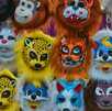Un grupo de máscaras de diferentes tipos de animales hechas de plástico en un puesto de máscaras de animales