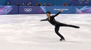 Patinador artísticos mexicano Donovan Carrillo sonriendo mientras levanta el puño al estar tumbado sobre una pista de hielo durante Juegos Olímpicos