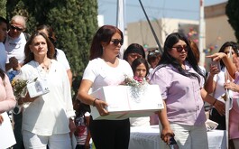 Mujer cargando pequeño féretro