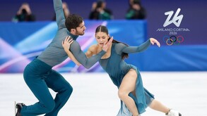 Pareja de competidores de patinaje artístico durante una competencia en Milano-Cortina 2026.